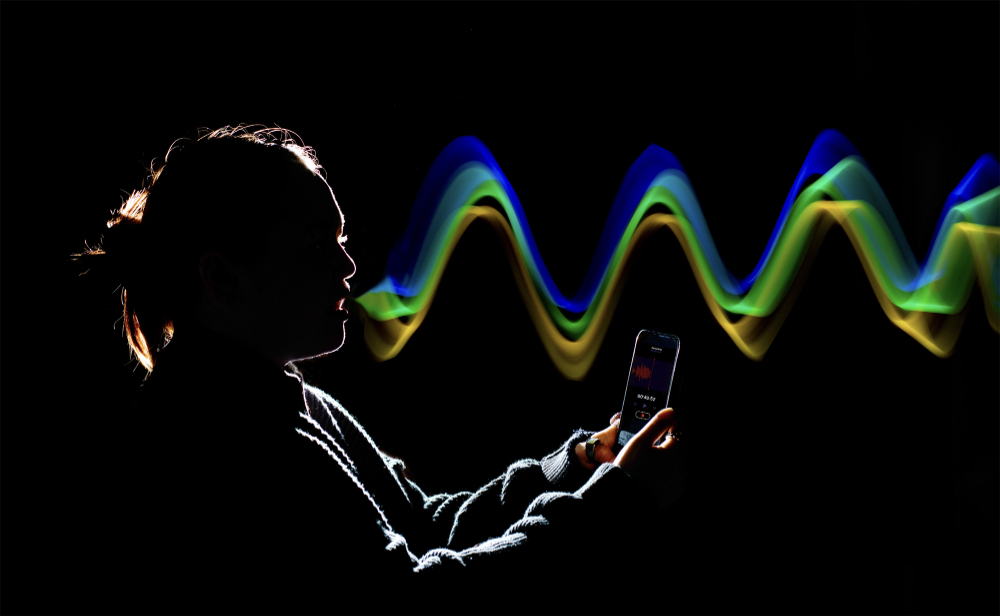 silouette of person with rainbow sound waves coming from her mouth, waves created in photoshop after photo was taken