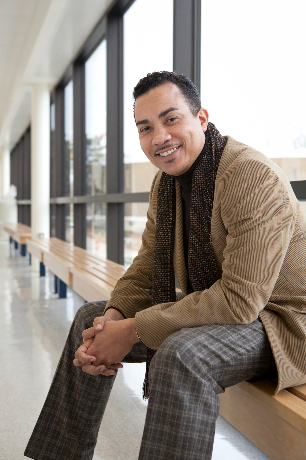 Steeve Buckridge sits on a bench inside a campus building