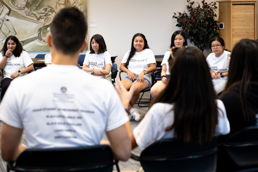 students sitting in chairs in a circle inside a room