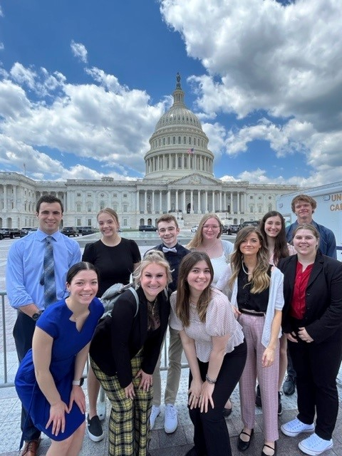 two rows of students standing in front of US Capitol building