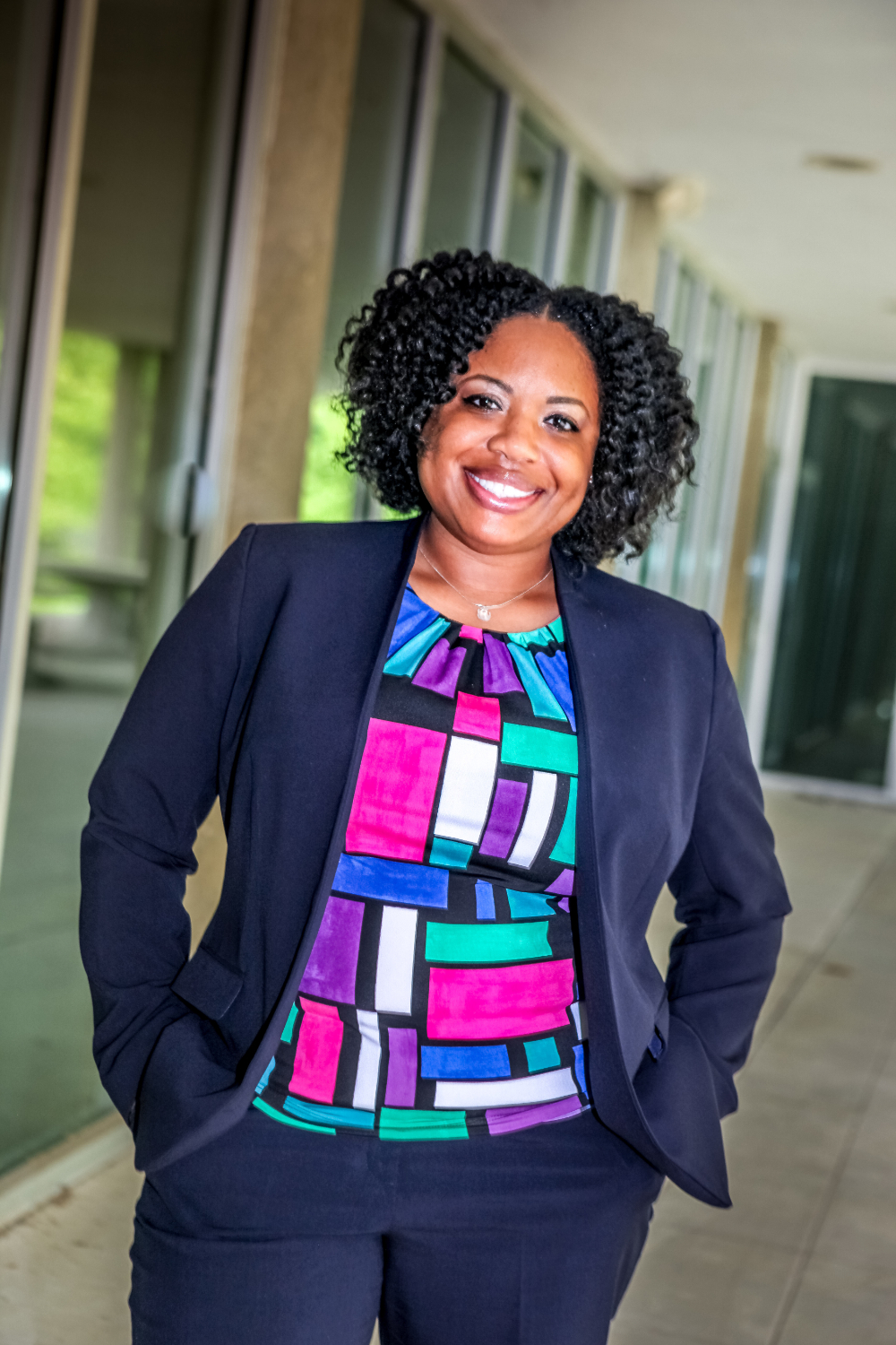 Clarice Thomas stands in a hallway with her hands in her suit pockets