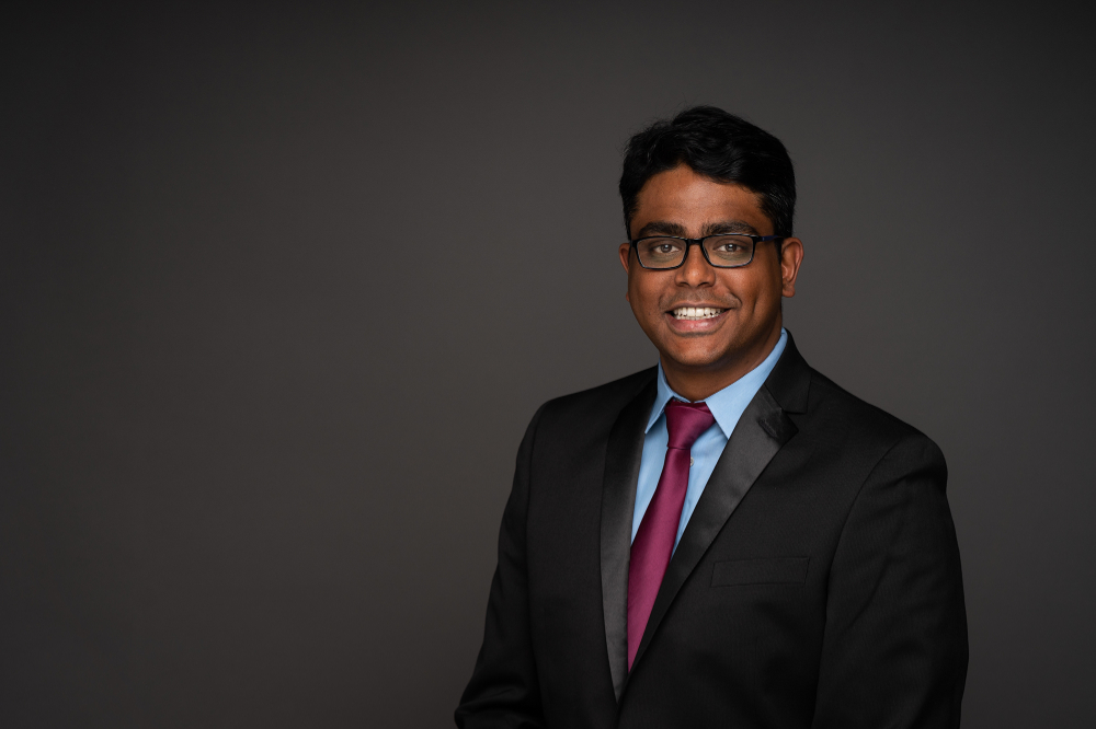 Abishek Balsamy-Kamaraj in a black jacket and blue shirt