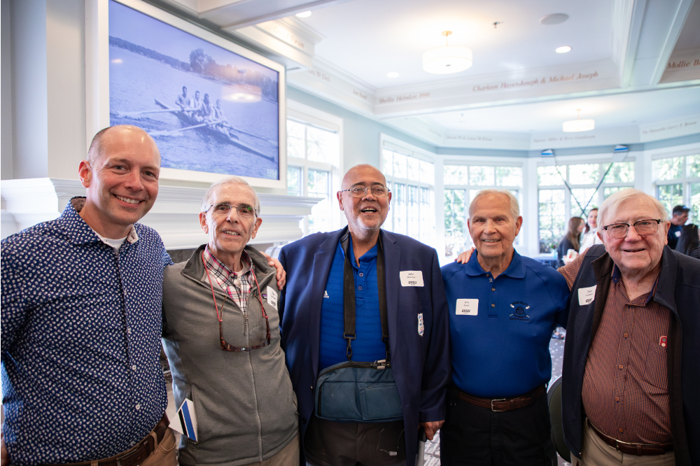five people stand in a row in the Alumni House