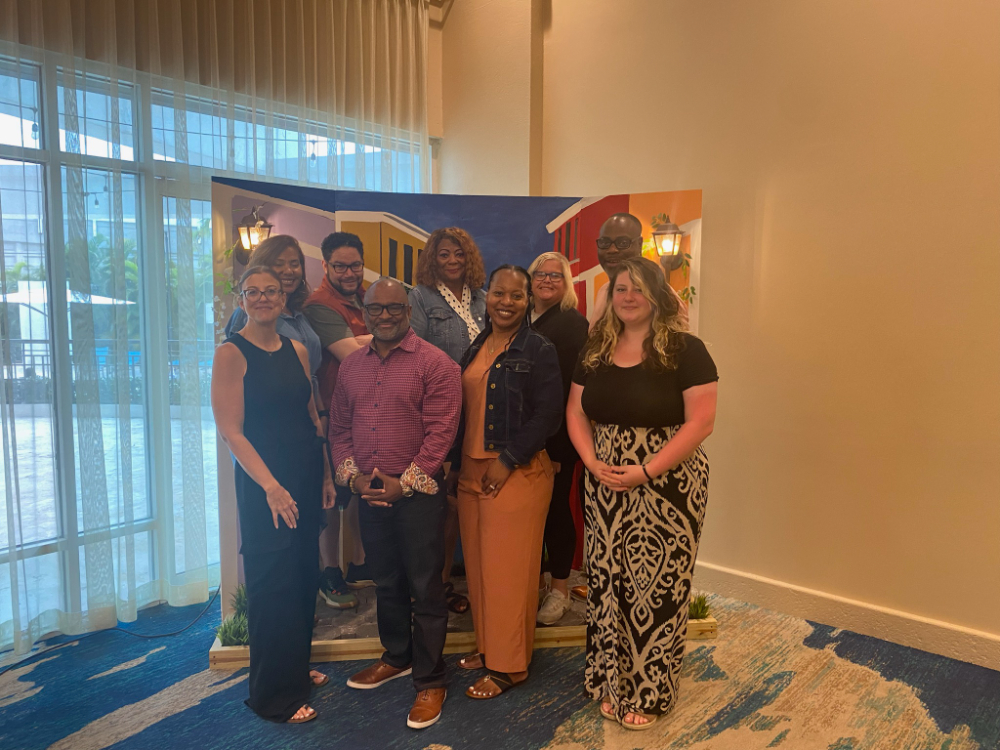 two rows of people standing in front of colorful backdrop in hallway