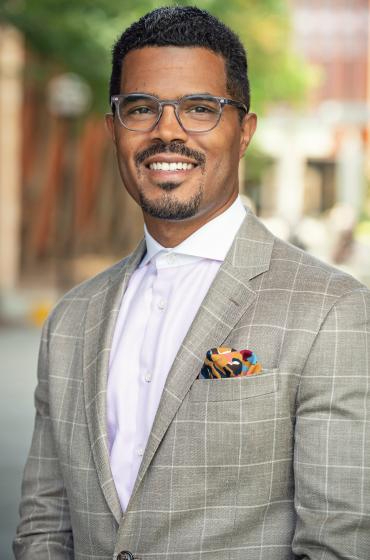 Charles Davis standing outside in suit coat and shirt, no tie
