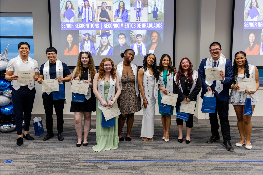 students in a row wearing stoles with Battle Creek Pipeline Scholars printed on them, holding certificates