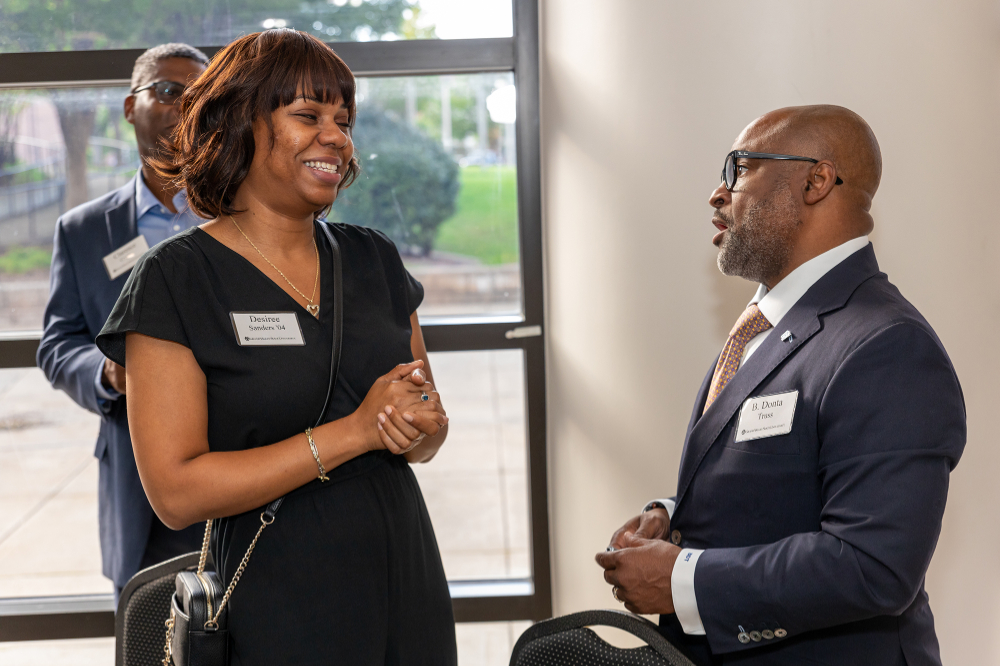 B. Donta Truss, vice president for Enrollment Development and Educational Outreach, talks with Desiree Sanders, '04, at the Southeast Michigan Ambassadors event.