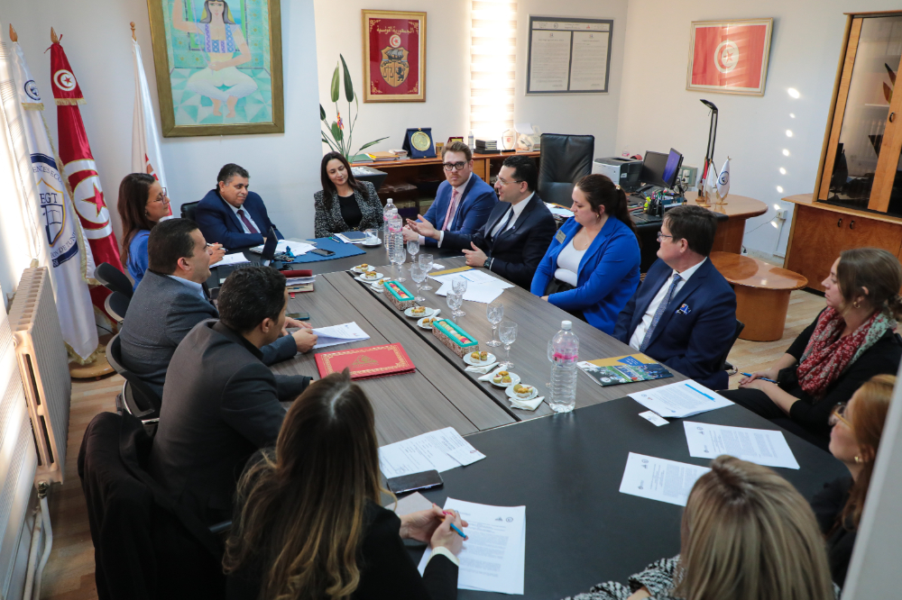 group of people seated at a conference table, with papers in front of them