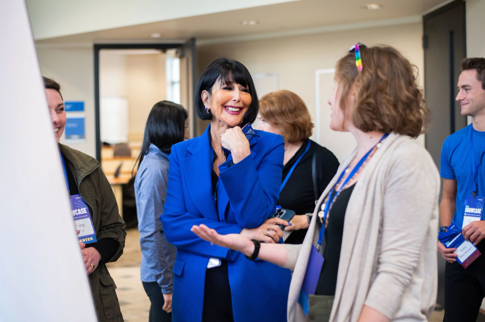 President Mantella on left chats with a participant at last year's Reach Higher Showcase