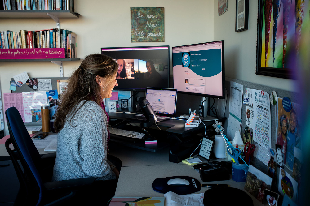 woman at desk delivering a podcast on Zoom, with another woman on screen
