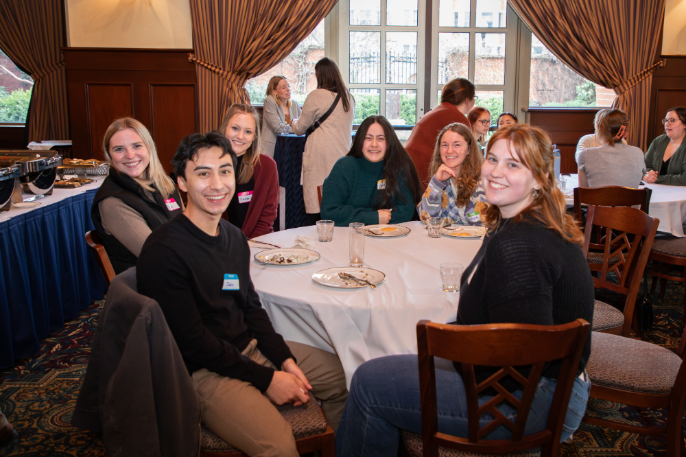 people seated at a table smiling for camera