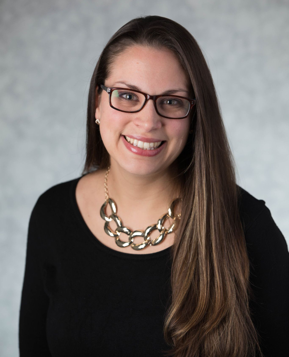 Jacquelynn Doyon-Martin in black shirt and chunky necklace, glasses