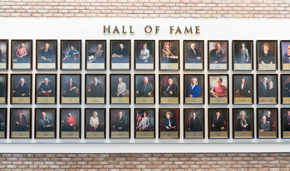 close up of portraits in the hall of fame that are three rows deep against a brick wall