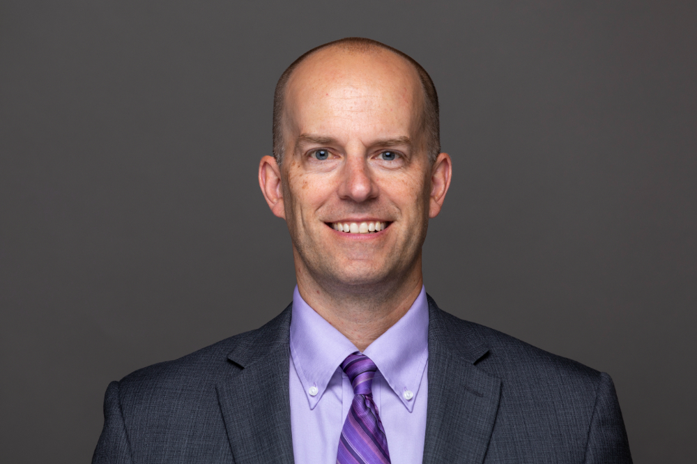 Denton Bobeldyk in purple shirt and tie and dark jacket