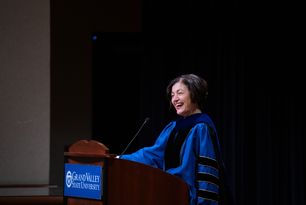 provost Fatma Mili smiles at podium