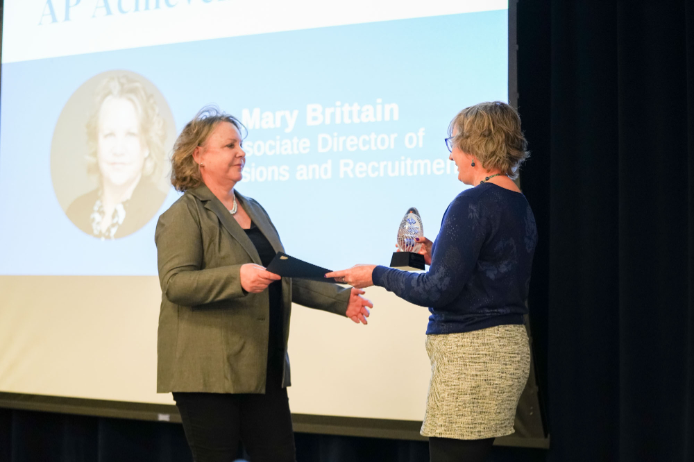 Mary Brittain, left, accepts an award from Pam Wells