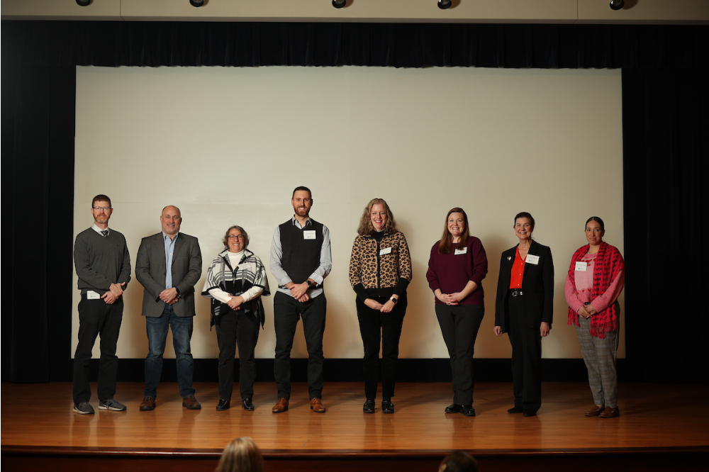 eight people lined up on stage