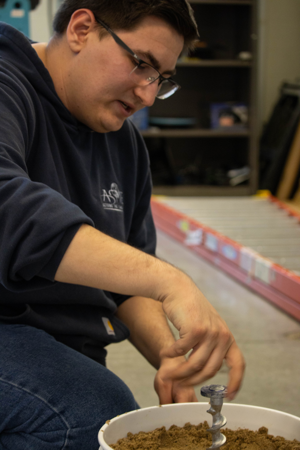 Scott Strayer,&nbsp;ASME vice president and Astro Anchors team captain, tests the bottom of the team's flagpole device in a bucket of sand.&nbsp;