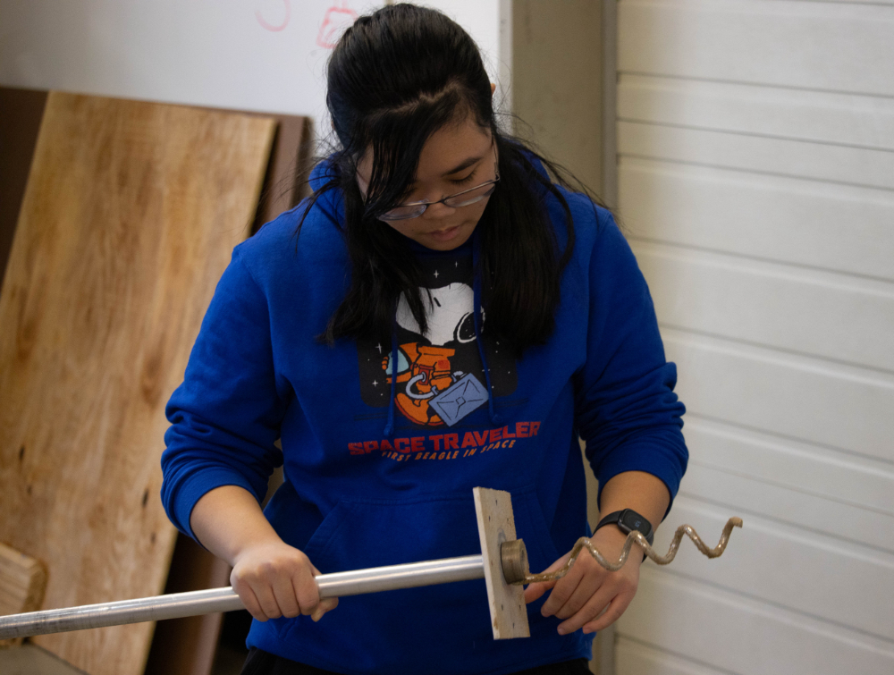 Dayna&nbsp;Straub holds a metal flagpole device with twisted metal on the end