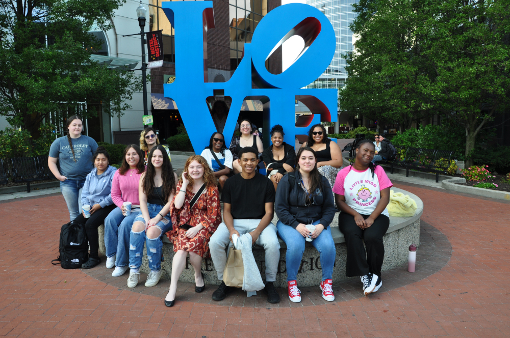 group of students pose around LOVE sculpture in Grand Rapids