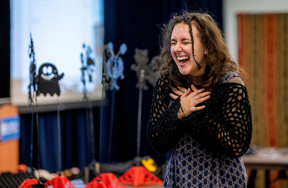 woman laughing and holding arms crossed in front of her chest