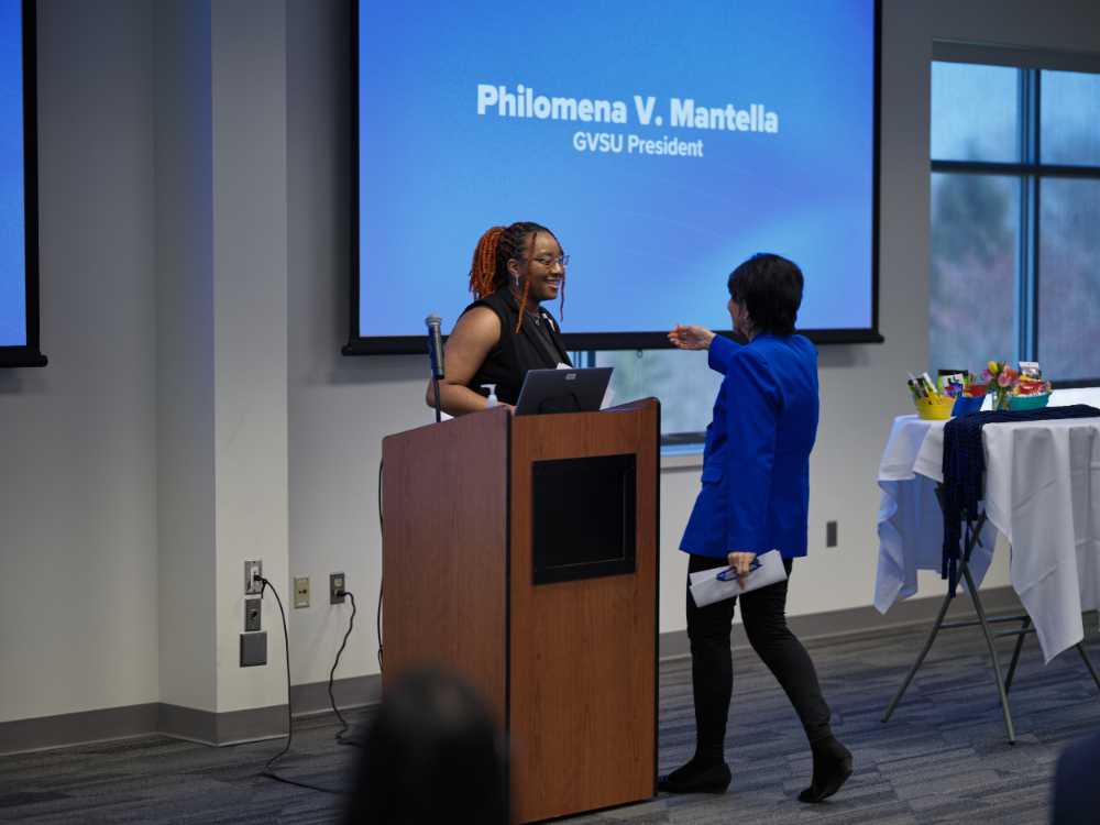 Robyn Settle at podium greeting President Mantella as she walks up to speak next