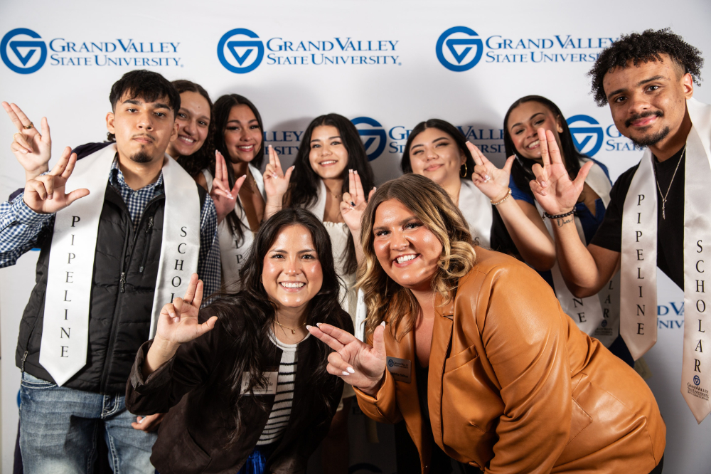 Battle Creek Pipeline Scholars are pictured in a photo booth photo with two staff members