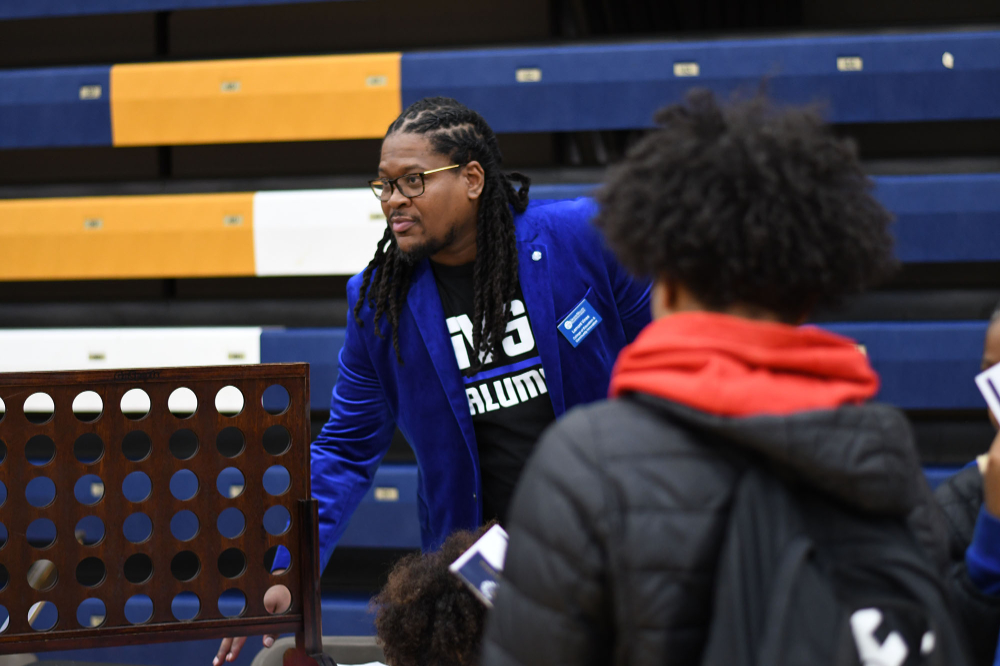 Lamont Vines, project coordinator and research associate for the College of Education and Community Innovation, is pictured near a table game at a career fair at Battle Creek Central High School