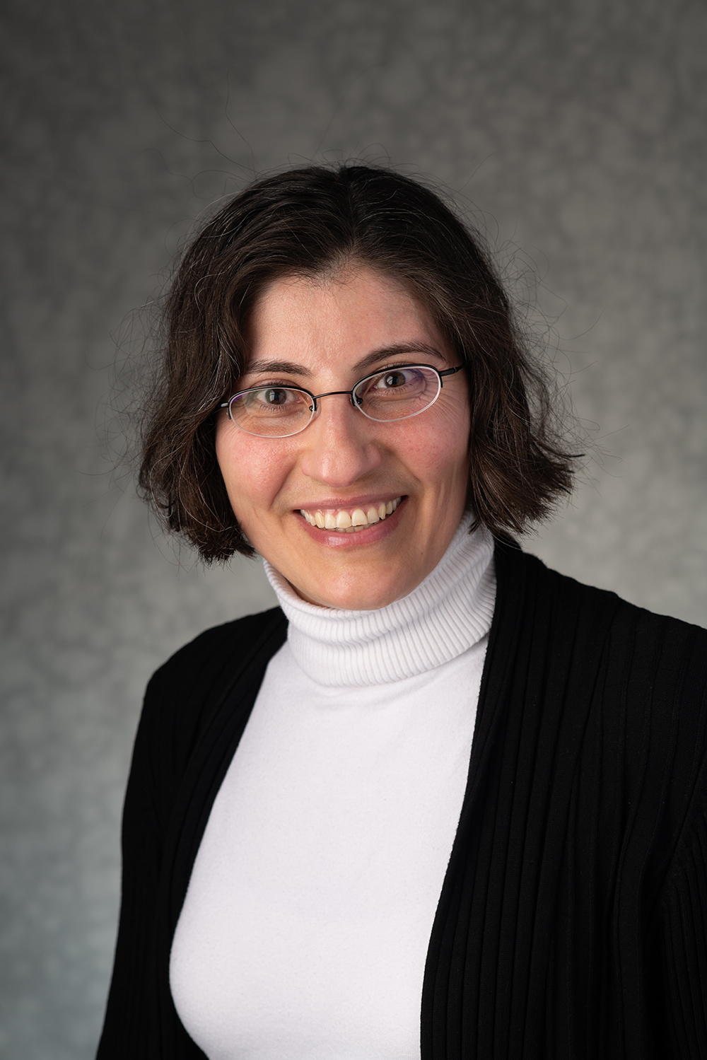 portrait of Feryal Alayont, professor of mathematics, who is wearing a white turtleneck and black jacket