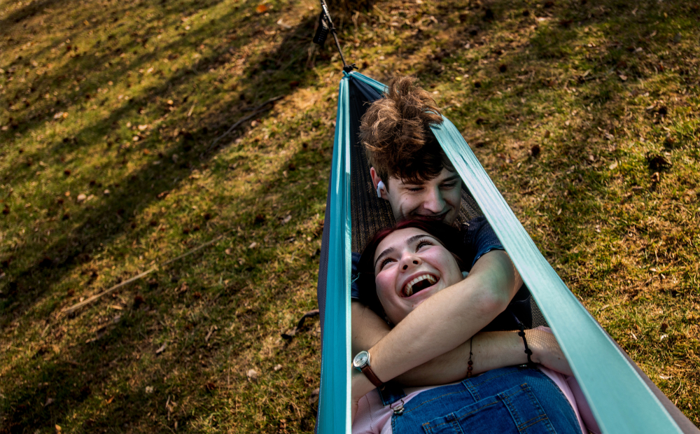 two people in a hammock taken from above, brown ground below