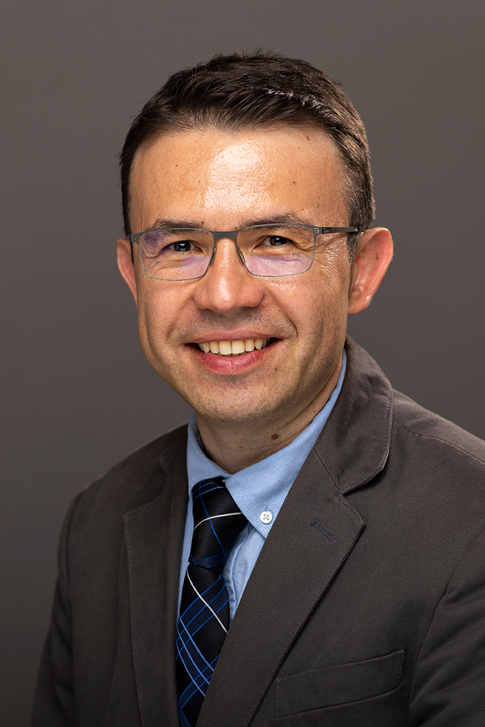 Headshot of Atilla Ozgar Cakmak, who is wearing a suitcoat with a blue shirt and tie