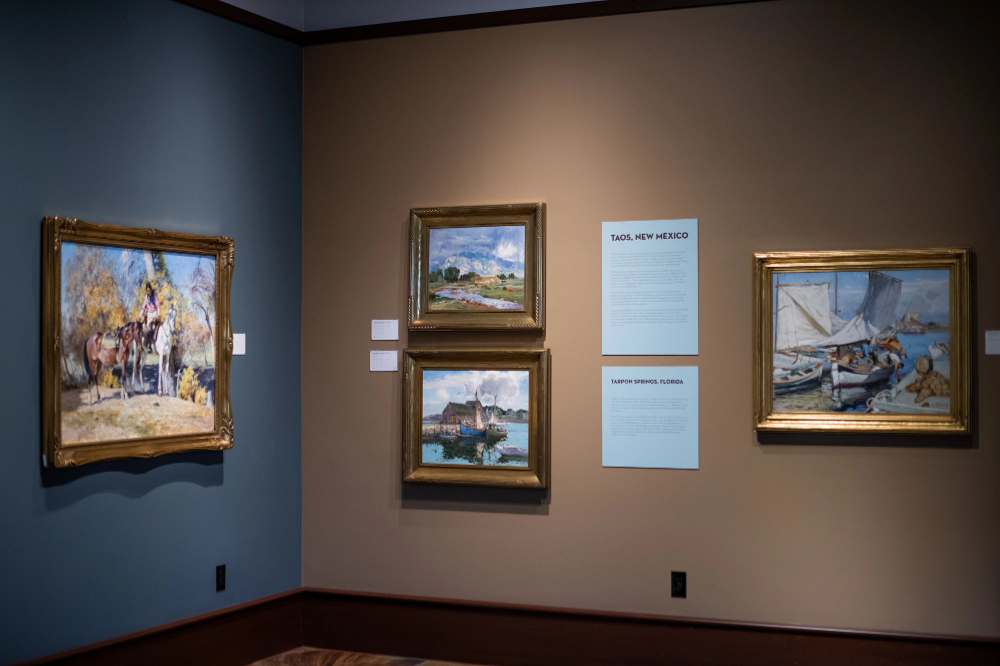 two gallery walls at corner, artwork on each wall, one wall blue other is beige
