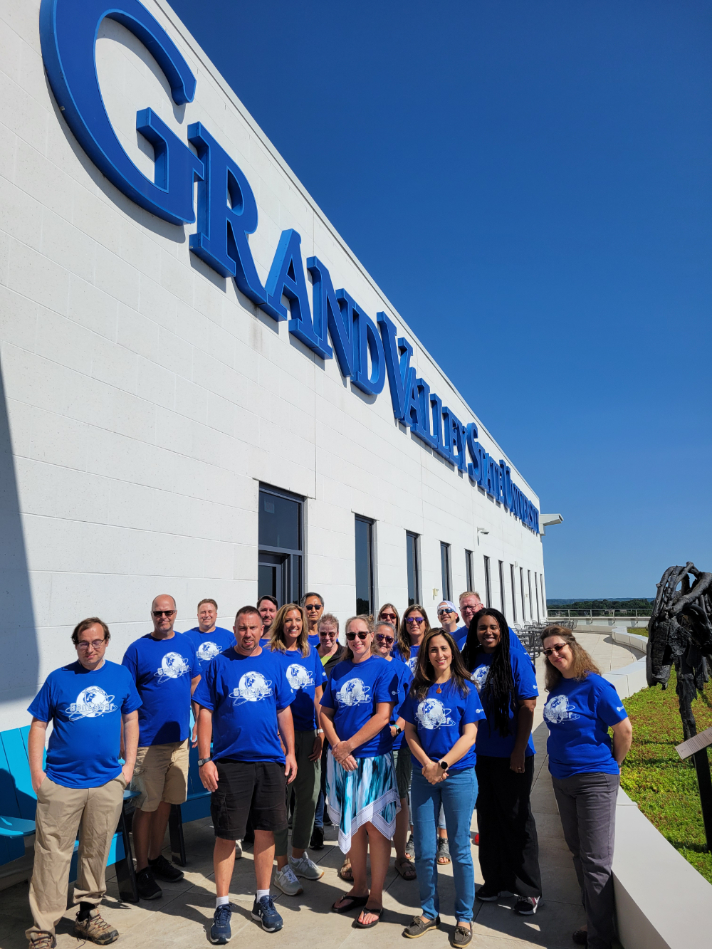 group of people standing on balcony of DCIH with GVSU lettering at top of buidling wall
