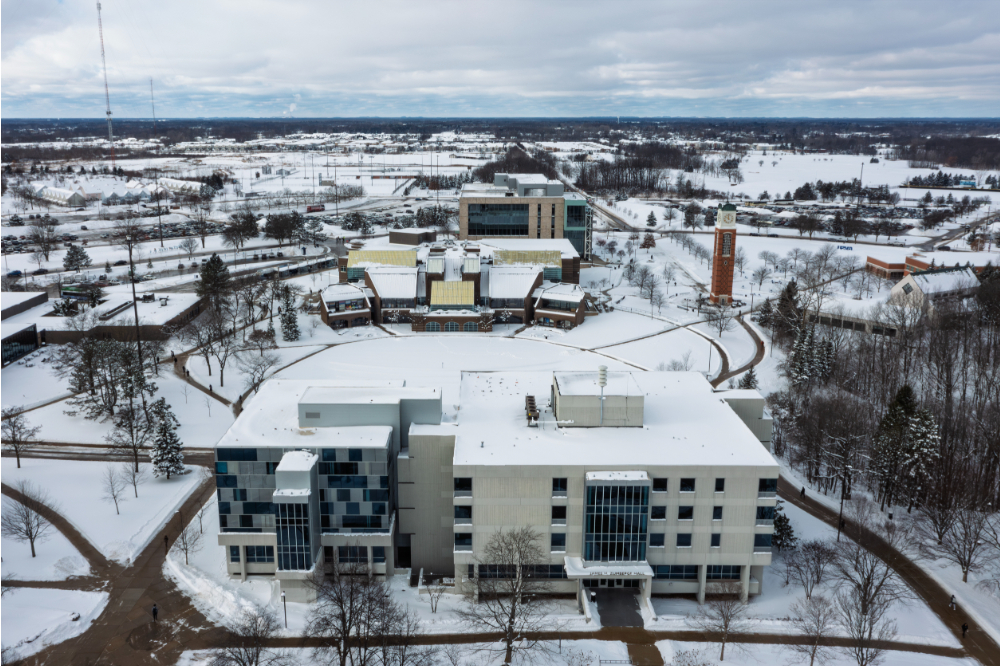 drone photo of snowy Allendale campus, with Zumberge Hall in forefront