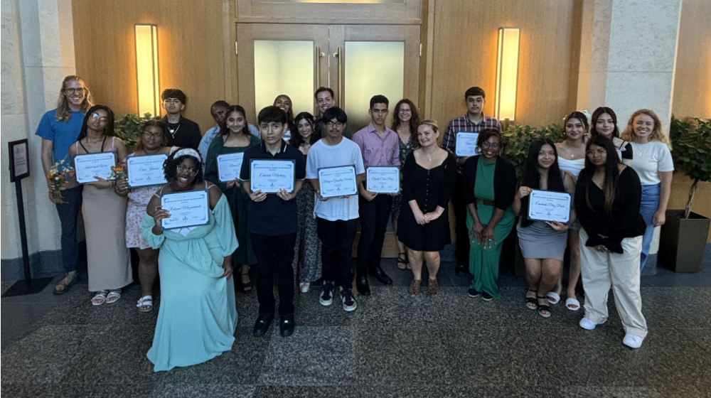 group of students and instructors standing in hallway, students holding certificates