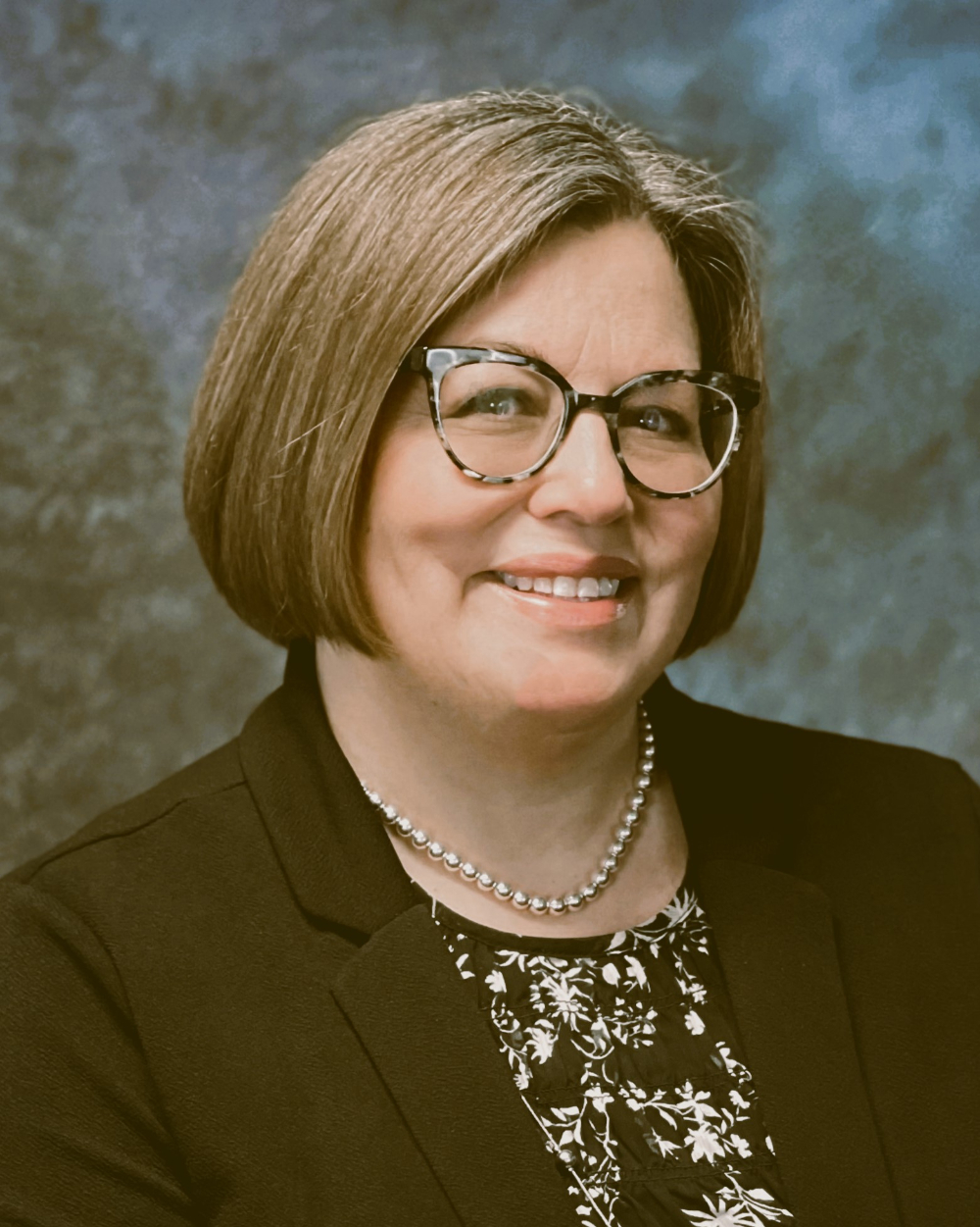 portrait of Jenni DuBois in brown jacket, print shirt
