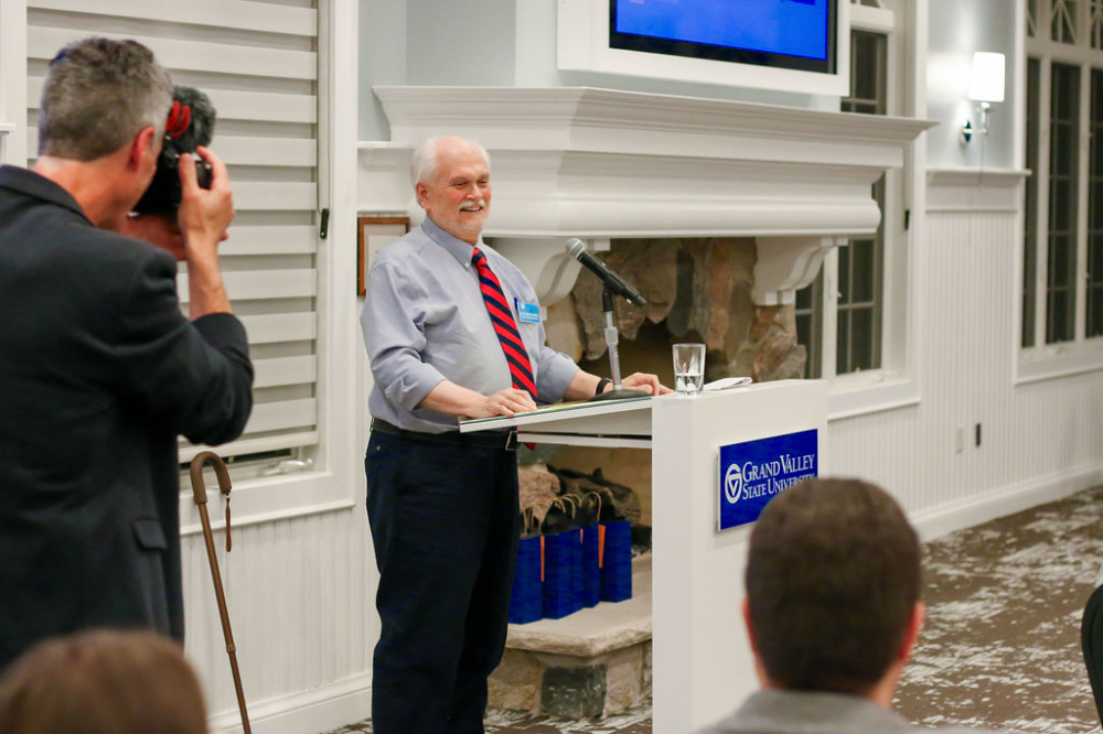 Alex Nesteranko behind podium at the Alumni House
