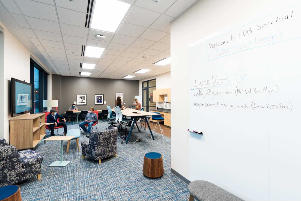 veterans lounge is pictured with whiteboard, table and chairs and screen mounted on wall.