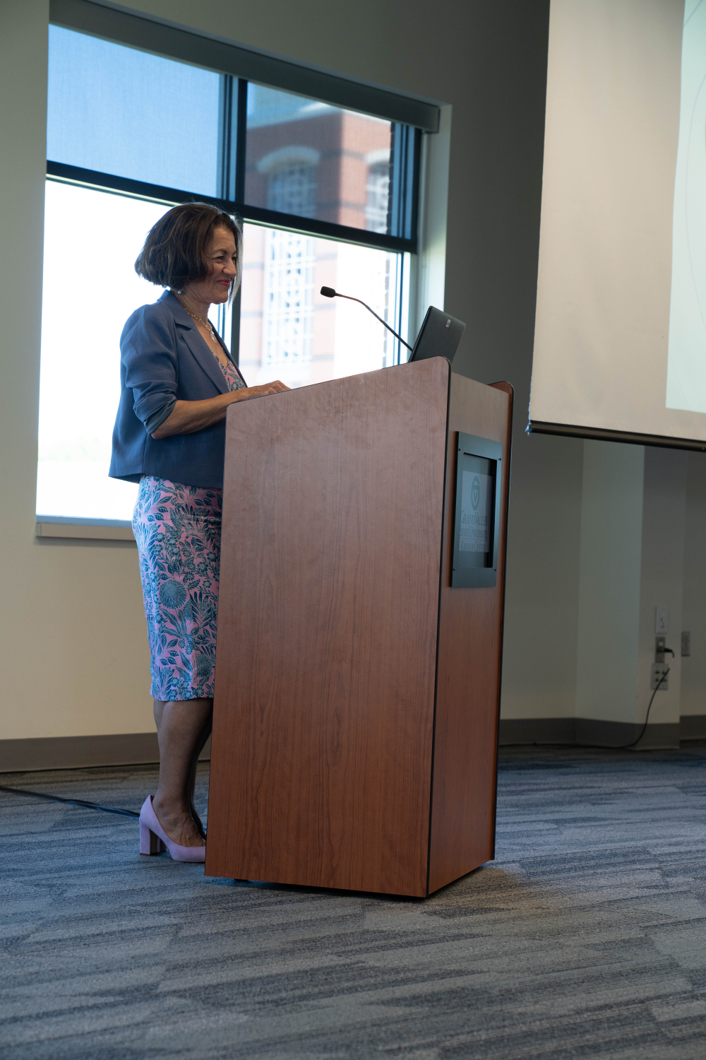 Fatma Mili standing at podium speaking to audience