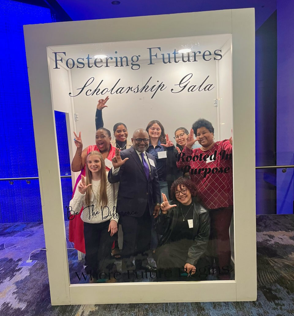 group of students, staff behind a frame, Fostering Futures Scholarship Gala, holding the Laker anchor sign