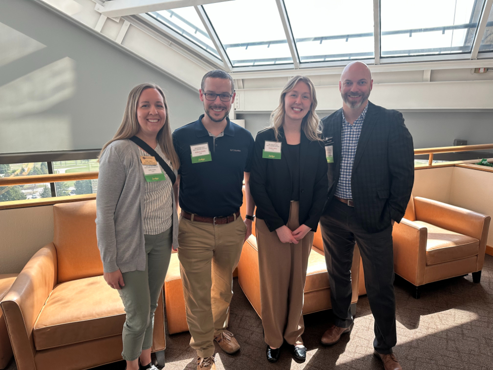 four people standing in a hallway