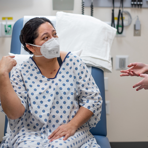 Miriam Johnston, a standardized patient trained to speak only in Spanish, communicates with Alyssa Bartle, at right, during a simulation in the Cook-DeVos Center for Health Sciences. Johnston has makeup on her chest created to look like cigarette burns.