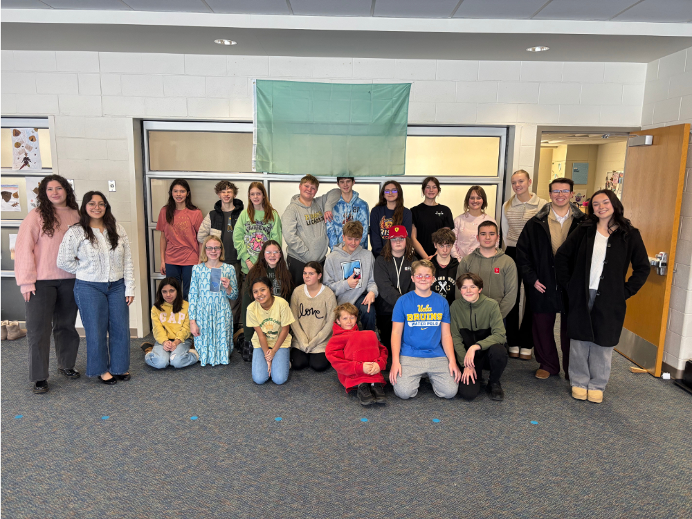 large group of GVSU students in a classroom with seventh- and eighth-graders