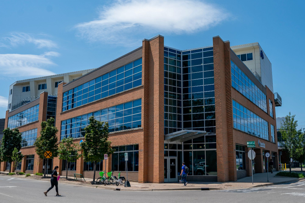 GVSU's Bicycle Factory is pictured, one person crossing the street in front