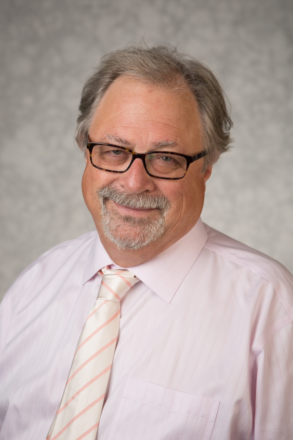 Charles Baker-Clark in pink shirt and striped tie