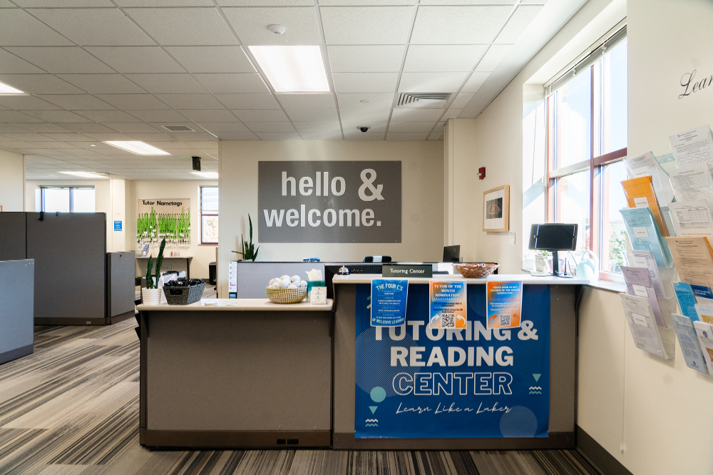 the reception desk at the Tutoring and Reading Center is pictured; sign behind desk reads Hello and Welcome