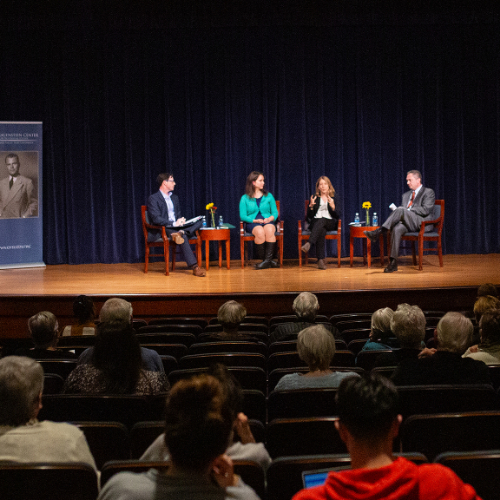 four people seated on stage, two Hauenstein Center for Presidential Studies vertical banners on stage left and right