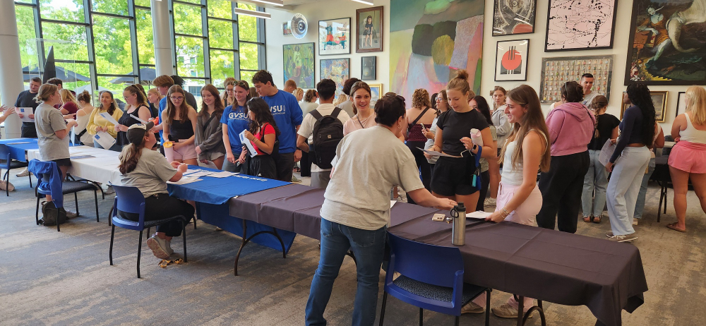 people stand around tables at welcome event
