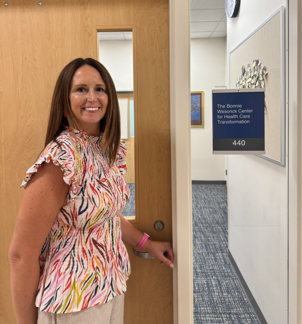 Leanne Mauriello stands in front of an office door