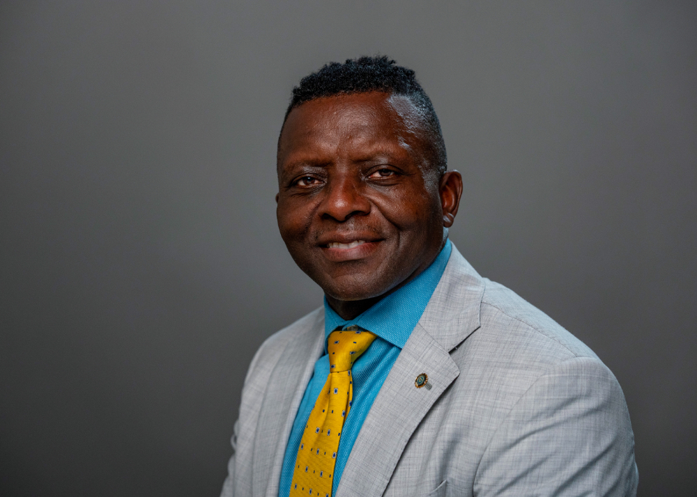 Felix Ngassa in blue shirt, yellow tie and gray jacket